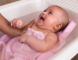 Smiling baby in a bath chair