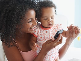 Smiling mom and baby looking at a phone