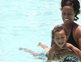 Mom holding a baby swimming in a pool