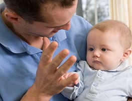 Baby looking at dad's hand