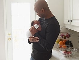 Dad holding a sleeping newborn baby