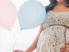 Week 31 pregnant woman holding balloons