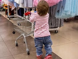Toddler pushing a push cart in a store